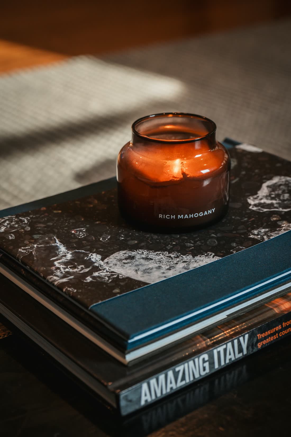 A candle on a stack of books before dawn